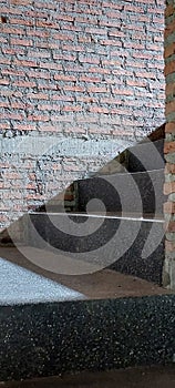 light and shadow in to stairwell on cement stairs case brick wall