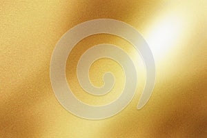 Light shining on gold painted metal sheet with copy space, abstract texture background