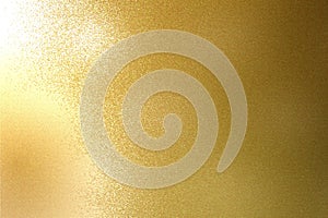 Light shining on rough gold metal sheet texture, abstract background