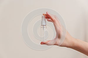 Light-skinned Asian woman holding a hand sanitizer spray bottle. Shows hygiene and cleanliness for virus or bacterial spread