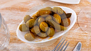 Light snack - bowl with pickled green olives and small cucumbers, gherkins