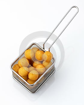 Light snack, delicious fried croquette balls in a metal sieve or colander. Object isolated on white background. Tasty