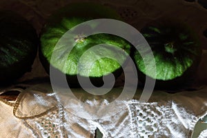 LIGHT ON SOME GREEN FIGS ON A WHITE ANGLAISE CLOTH