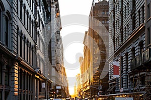 The light of summer sunset shines between the buildings on 19th Street in New York City