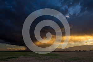 Light from the sunset illuminates falling rain.