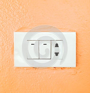 Light switch broad on orange wall