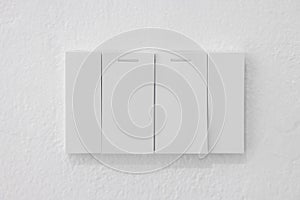 Light switch, Close-up White plastic mechanical switch mounted on a white wall