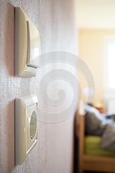 light switch and electrical outlet hanging on the wall of the living room