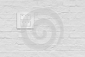Light switch on white brick wall.