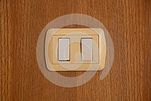 Light switch on a wooden wall close-up