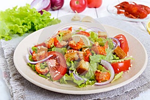 Light tasty salad with meat of a cancer, shrimps, lettuce, garlic croutons, tomatoes, red onions