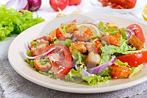 Light tasty salad with meat of a cancer, shrimps, lettuce, garlic croutons, tomatoes, red onions