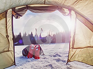 Light tent set on snow in winter forest in mountains