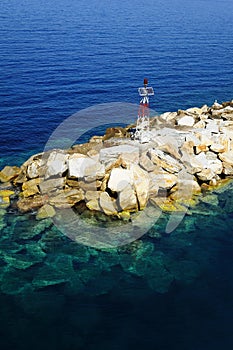 Light tower above rocks in the Aegean