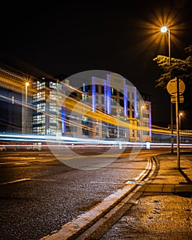 Light trails of cars moving past a modern apartment block