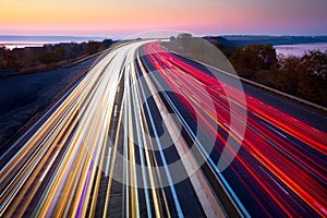 Light trails of cars on the road. Sunset time. Transport creative background. Long exposure, motion and blur