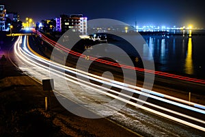Light trails of cars at seaside motorway in the night long exposure
