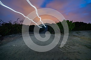 Light trails of couple walik or trekking on top Mount Maunganui on dark night