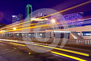 Light trails from moving streetcar on the Houston Street with the city of Dallas in background