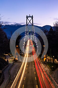 Light trails from traffic on a suspension bridge with mountains in the background - Lions Gate Bridge, Vancouver Canada