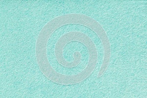 Light turquoise matt suede fabric closeup. Velvet texture of felt