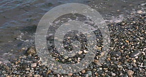 light waves washing over a gravel beach