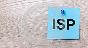 On a light wooden background - a light blue square sticker with the text ISP Internet Service Provider