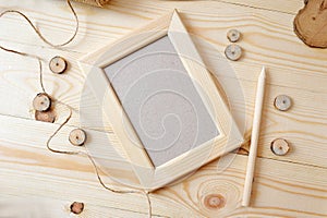 Light wooden frame on a wooden background. Flat lay, top view photo mockup