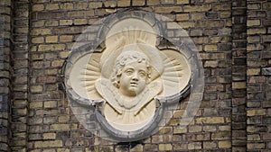 Light yellow angel on a brick wall.