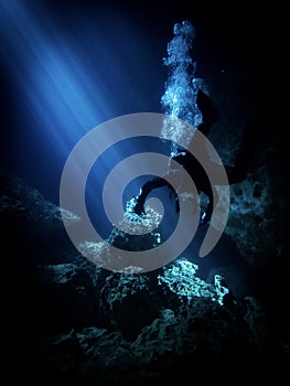 Lightbeams illuminate diver in the flooded underground cavern at Devil's Den, Williston Florida