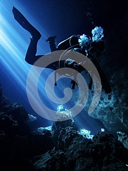 Lightbeams illuminate diver in the flooded underground cavern at Devil's Den, Williston Florida