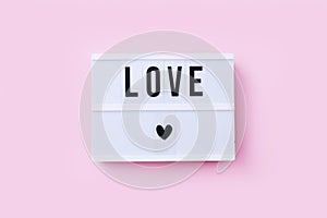 Lightboard with word Love on pink background. Valentine`s day or wedding party concept.