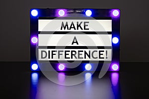 Lightbox with green lights in dark room with words - make a difference
