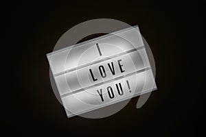 Lightbox with inscription I LOVE YOU glows in dark on black background