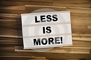 Lightbox or light box with business message Less is more on wooden background table