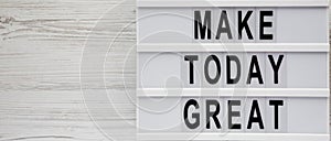 Lightbox with `Make today great` words on a white wooden background, top view. Overhead, from above. Flat lay. Copy space