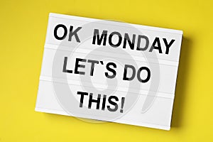 Lightbox with motivational quote Ok Monday Let`s Do This! on yellow background, top view