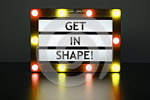 Lightbox with red and orange lights in dark room with words - Get in shape