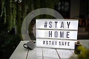 Lightbox sign with text hashtag #STAY HOME and #STAY SAFE with cactus pot home decor. COVID-19. Stay home save concept