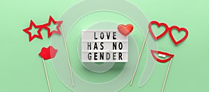 Lightbox with slogan LOVE HAS NO GENDER, red paper props glasses and lips on pastel green ash color background