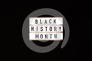 Lightbox with text BLACK HISTORY MONTH on dark black background. Message historical event