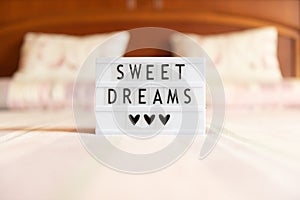 Lightbox with text: sweet dreams, on the bed