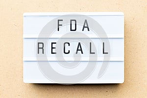 Lightbox with word fda recall on wood background photo