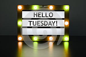 Lightbox with yellow and orange lights in dark room with words - Hello Tuesday