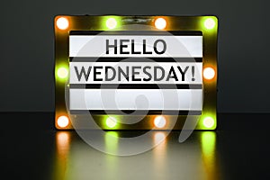 Lightbox with yellow and orange lights in dark room with words - Hello Wednesday