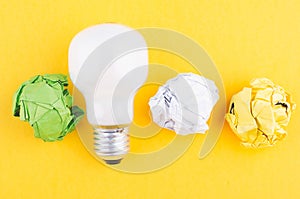 Lightbulb and crumple paper on yellow background