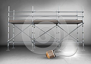 Lightbulb in front of scaffolding in grey room photo