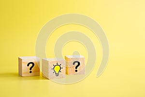 Lightbulb icon and question mark print screen on wooden block cube