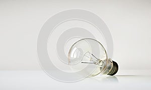 Lightbulb lying on bright background with copy space