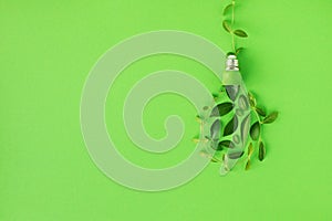 Lightbulb and power cord from green leaves concept top view. Renewable and saving energy. Ecology and environment sustainable